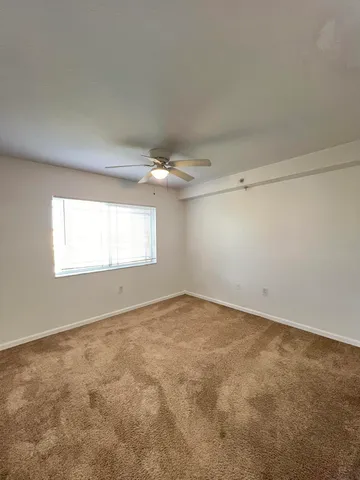 an empty room with an empty space and a ceiling fan