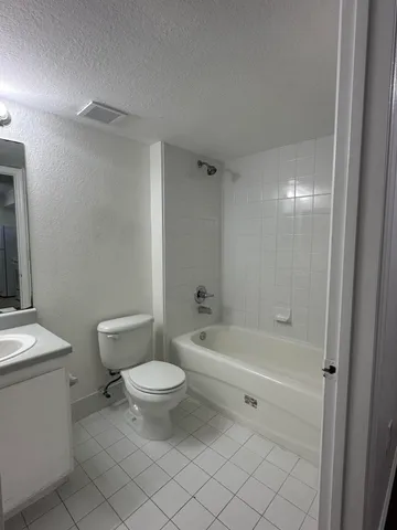 a bathroom with a double vanity sink mirror and bathtub