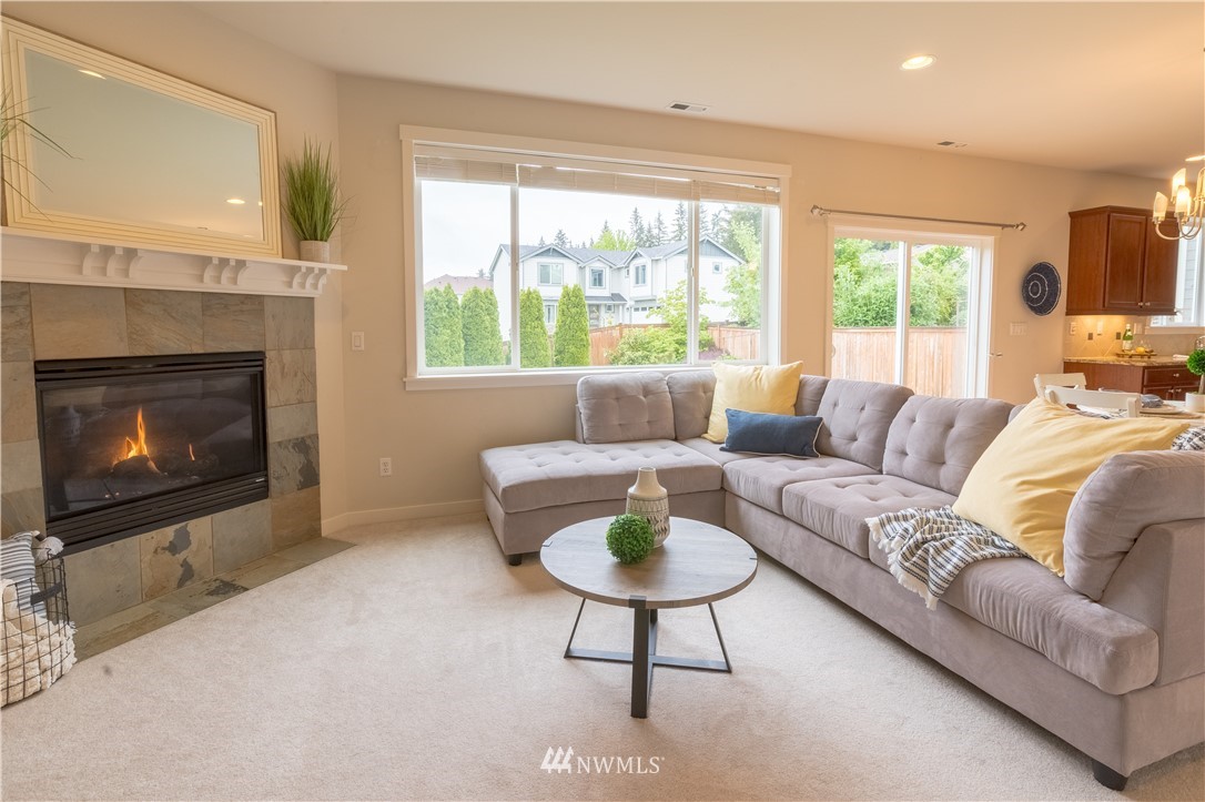 4407 219th Street Southeast Bothell, WA 98021 - Photo 17 of 33 a living room with furniture a large window and a fireplace
