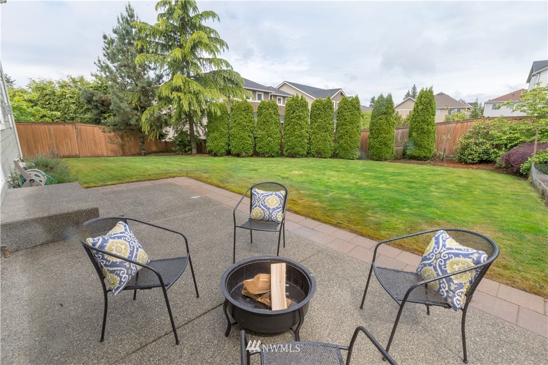 4407 219th Street Southeast Bothell, WA 98021 - Photo 28 of 33 a view of a backyard with table and chairs potted plants and wooden fence
