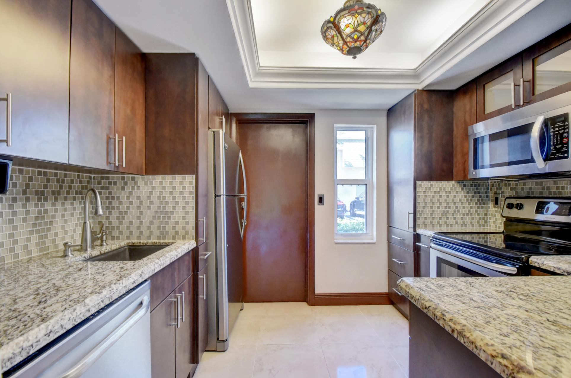 1845 Northwest 4th Avenue, Unit 16 Boca Raton, FL 33432 - Photo 11 of 37 a kitchen with stainless steel appliances granite countertop a refrigerator and a sink