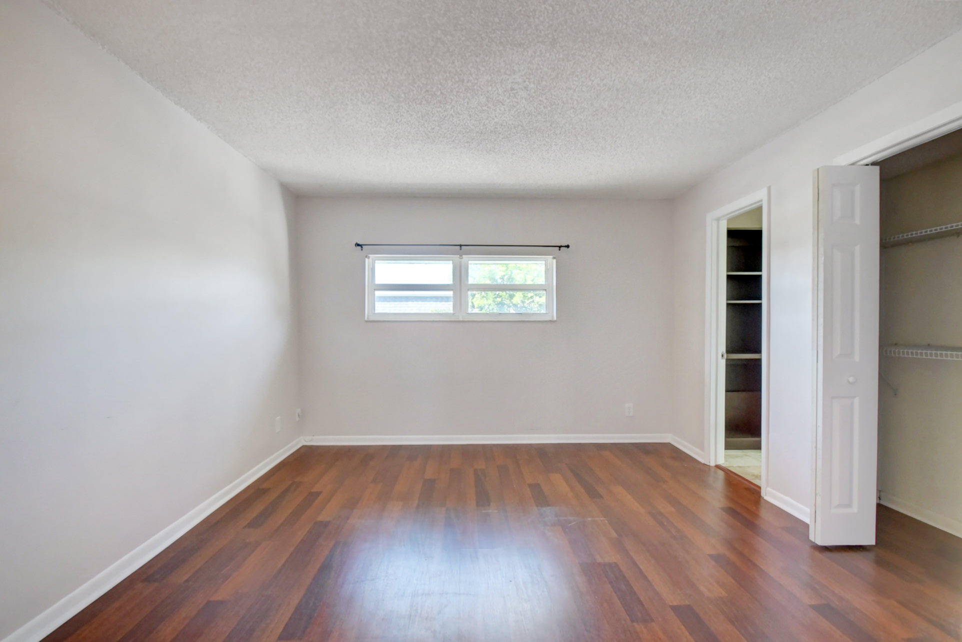 1845 Northwest 4th Avenue, Unit 16 Boca Raton, FL 33432 - Photo 21 of 37 an empty room with wooden floor and windows