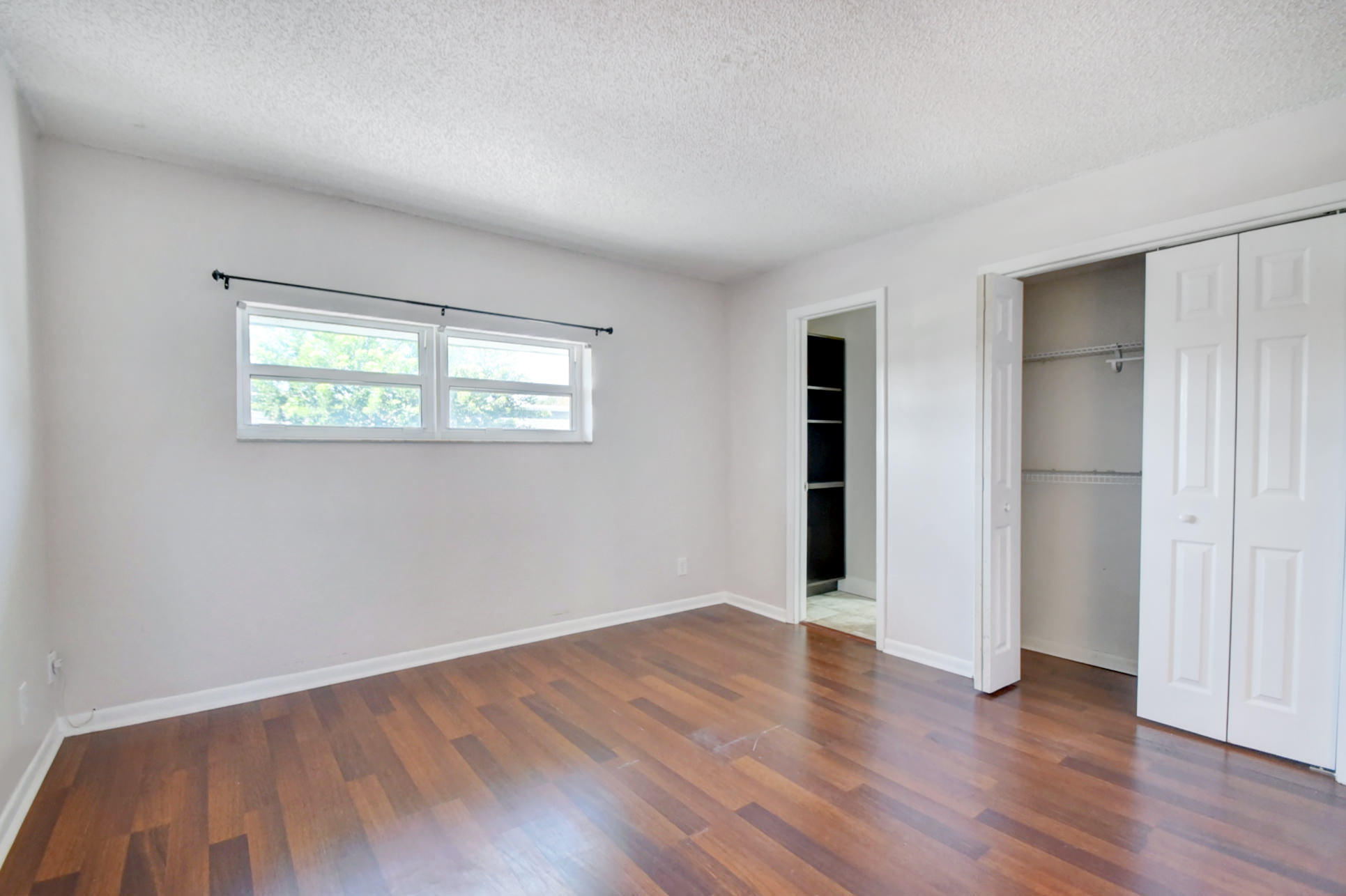 1845 Northwest 4th Avenue, Unit 16 Boca Raton, FL 33432 - Photo 24 of 37 an empty room with wooden floor and windows