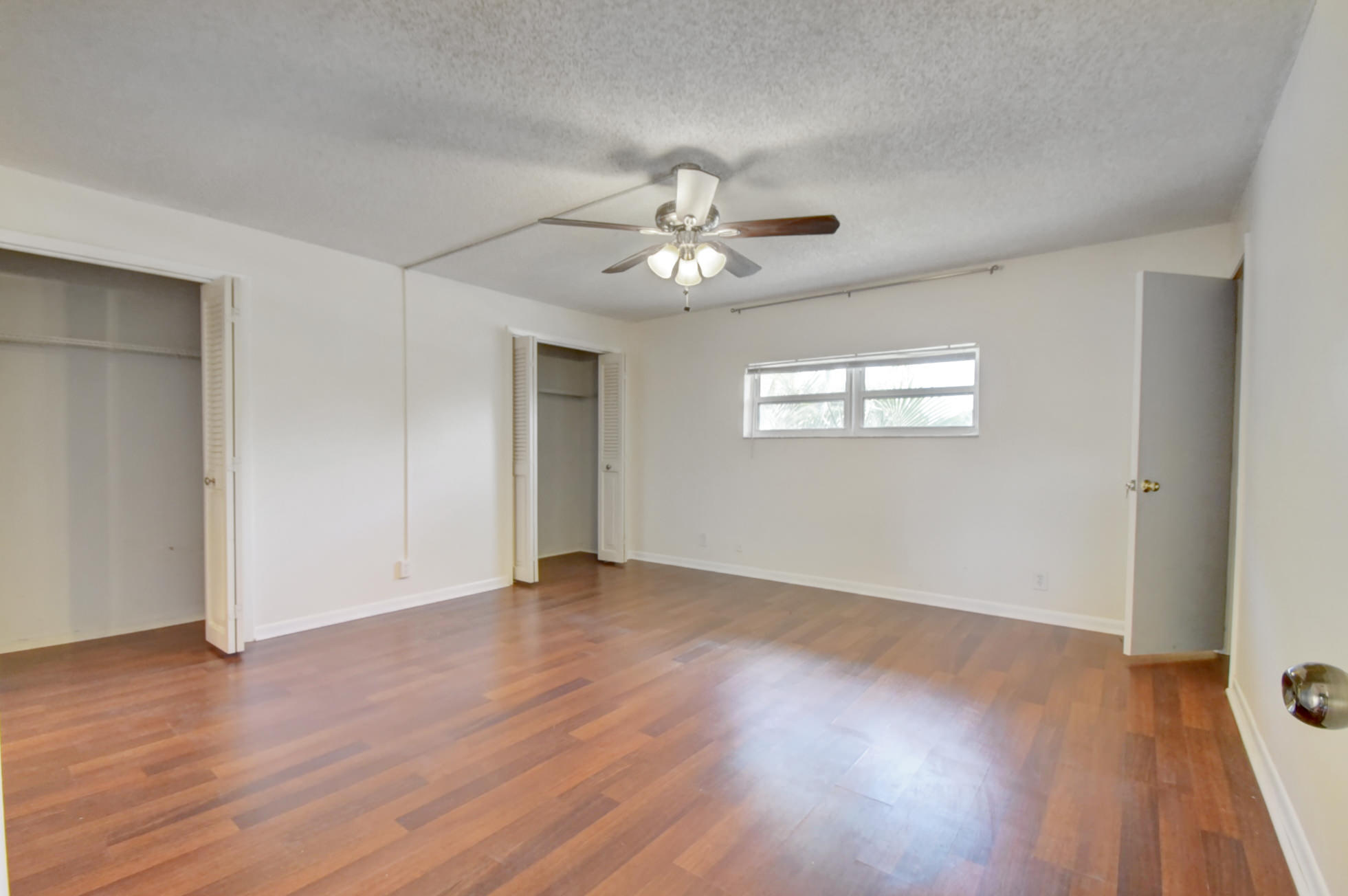 1845 Northwest 4th Avenue, Unit 16 Boca Raton, FL 33432 - Photo 27 of 37 a view of an empty room with wooden floor and a window