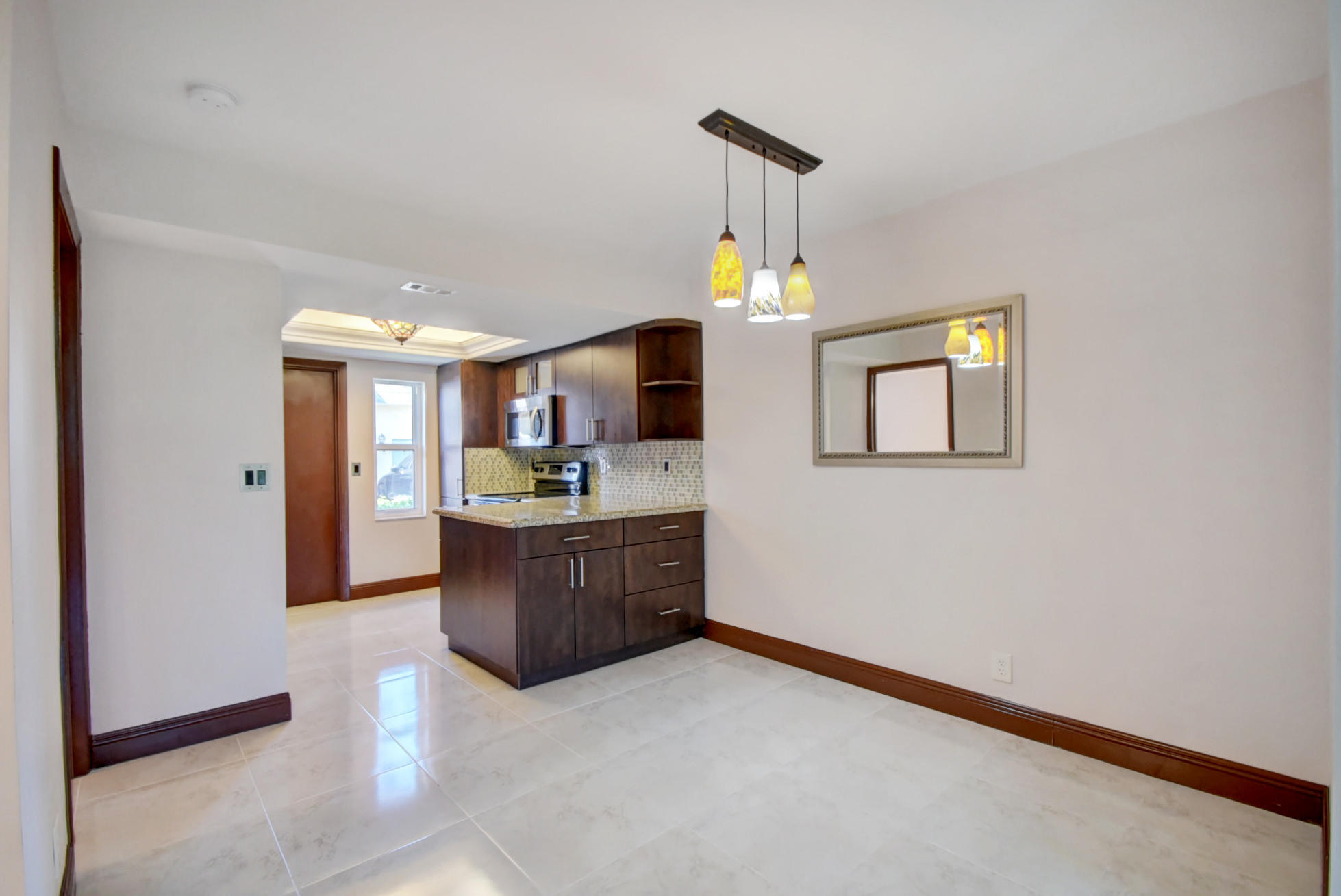 1845 Northwest 4th Avenue, Unit 16 Boca Raton, FL 33432 - Photo 6 of 37 a kitchen with stainless steel appliances a refrigerator and a fireplace
