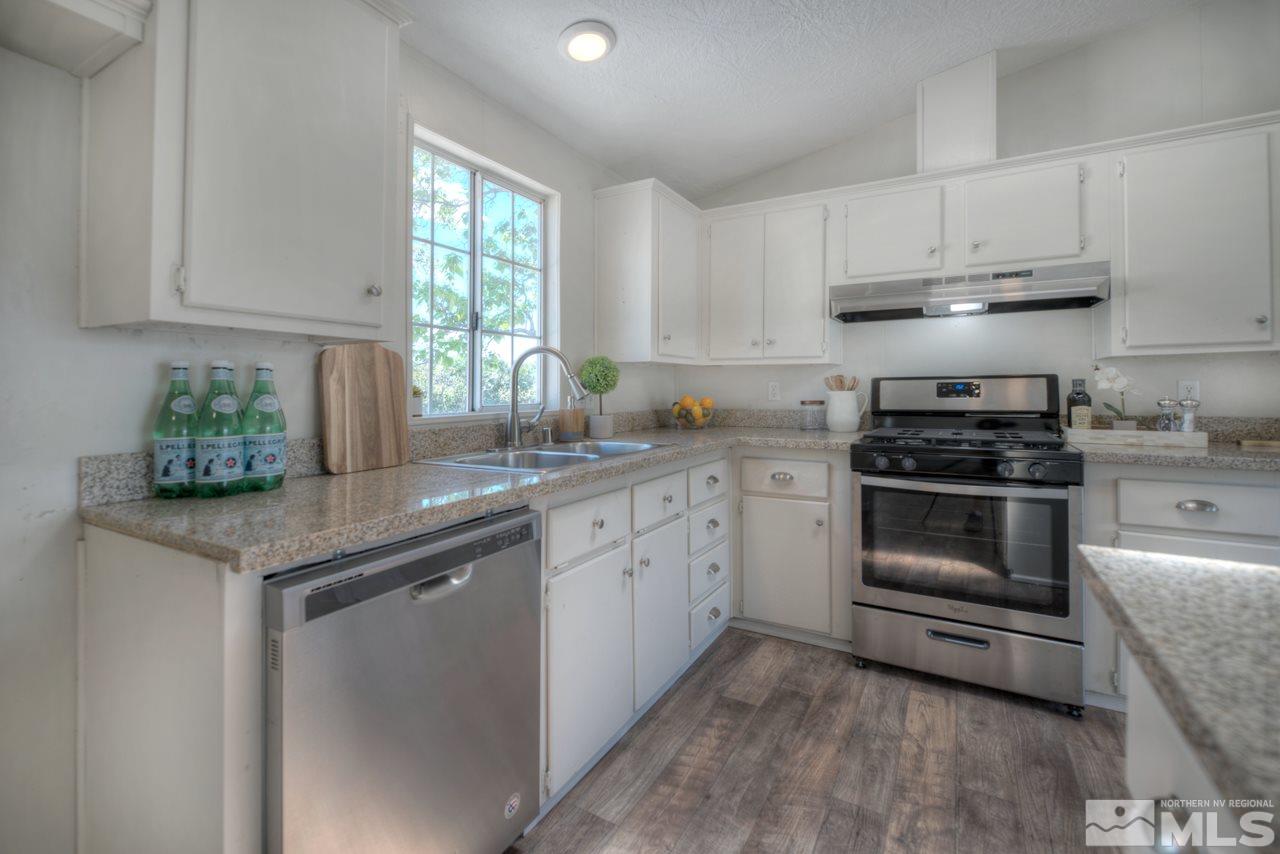 1380 Ricci Lane Fernley, NV 89408 - Photo 1 of 25 a kitchen with granite countertop a stove sink and cabinets
