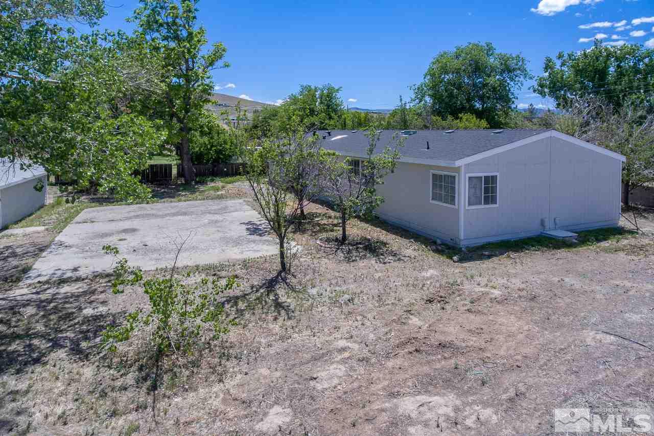 1380 Ricci Lane Fernley, NV 89408 - Photo 15 of 25 a house is sitting in middle of the green field