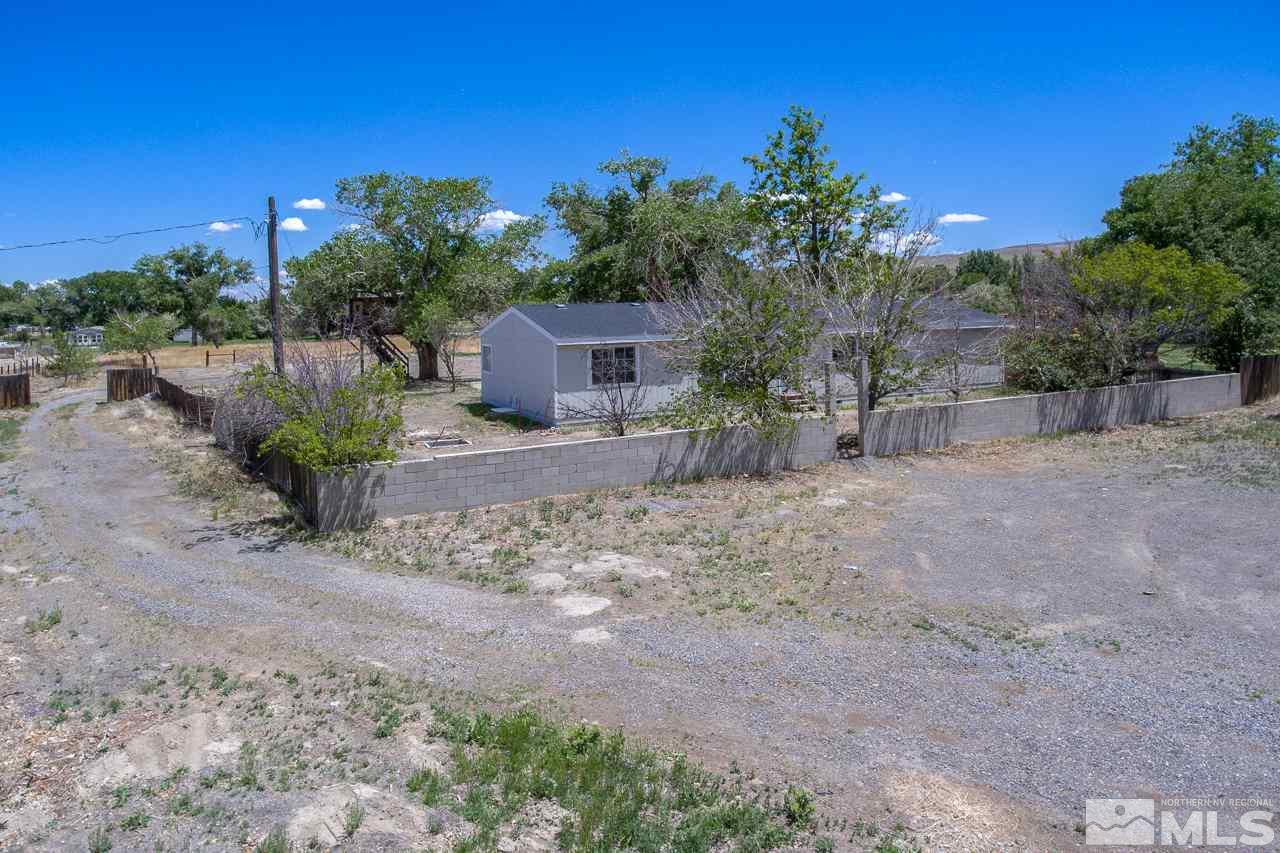 1380 Ricci Lane Fernley, NV 89408 - Photo 23 of 25 a view of a backyard with plants and a large tree