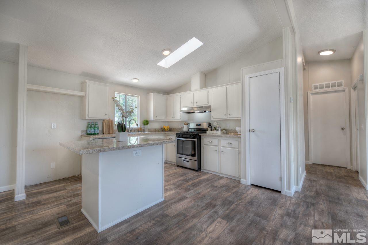 1380 Ricci Lane Fernley, NV 89408 - Photo 4 of 25 a kitchen with white cabinets and stainless steel appliances