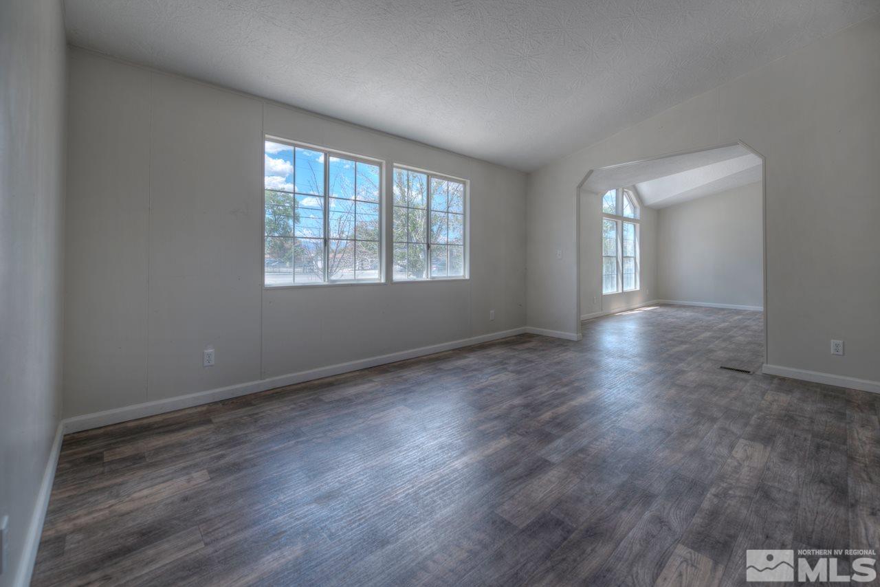 1380 Ricci Lane Fernley, NV 89408 - Photo 7 of 25 an empty room with wooden floor and windows