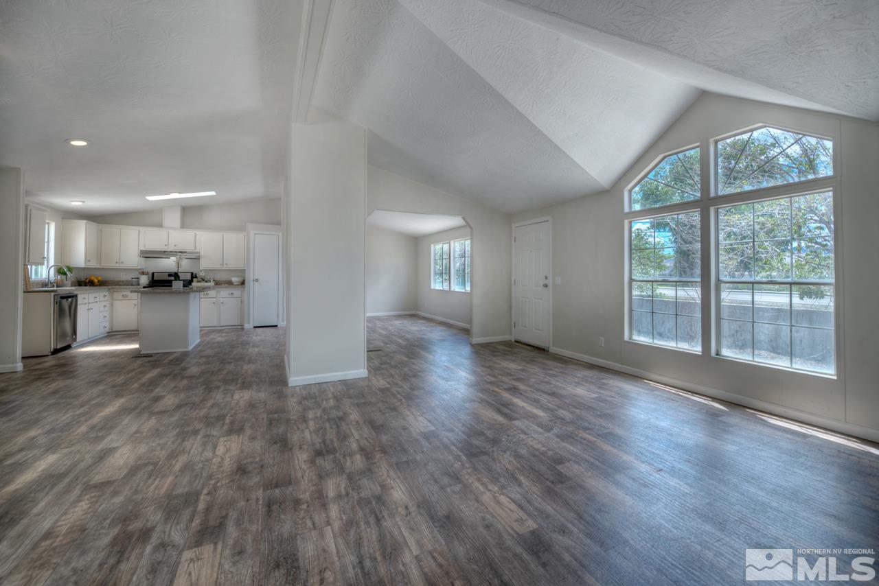 1380 Ricci Lane Fernley, NV 89408 - Photo 9 of 25 a view of empty room with wooden floor and windows