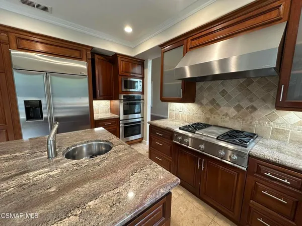a kitchen with stainless steel appliances granite countertop a stove and a refrigerator