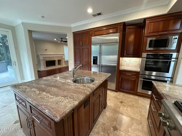 a kitchen with stainless steel appliances granite countertop a kitchen island a stove and a sink