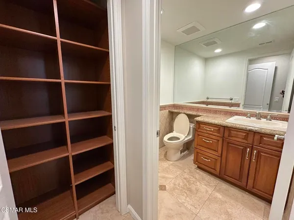 a bathroom with a granite countertop sink a toilet and a mirror