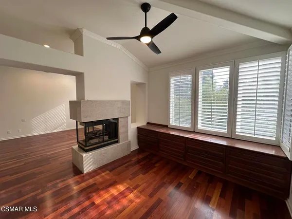 an empty room with wooden floor and fireplace
