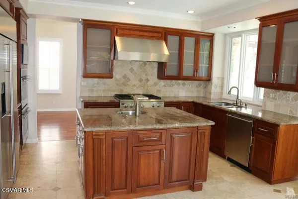 a kitchen with stainless steel appliances granite countertop a sink stove and cabinets