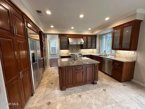 a kitchen with stainless steel appliances granite countertop a sink stove and refrigerator