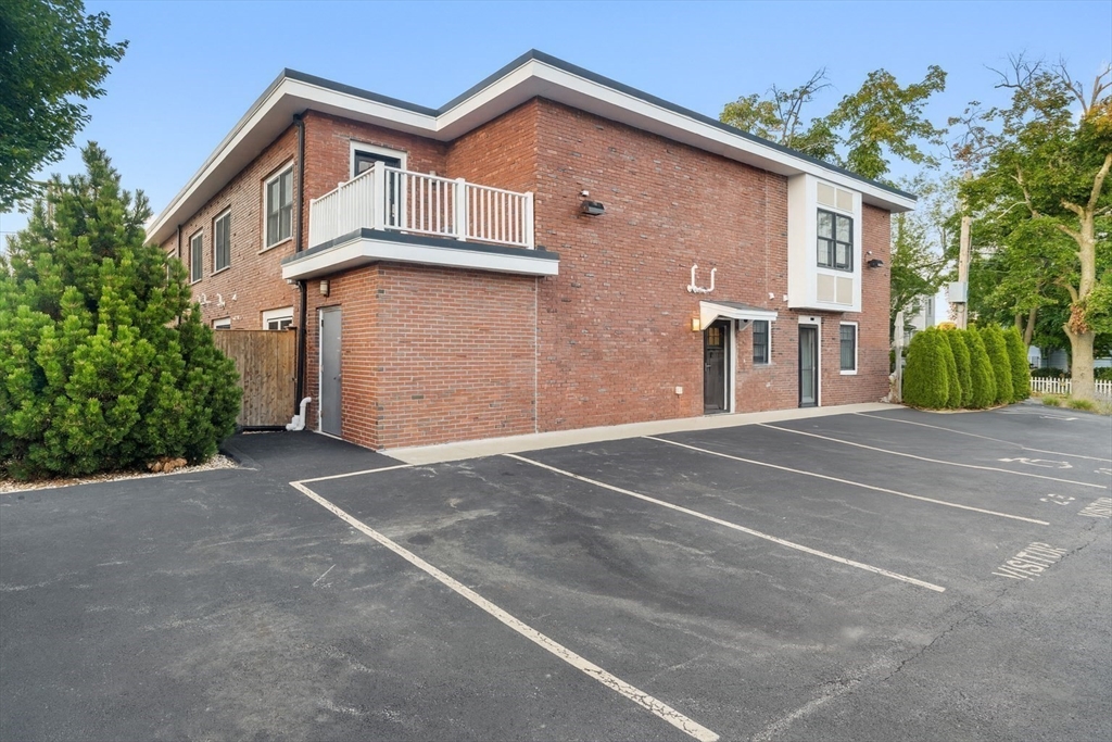 142 Pleasant Street, Unit 2 Winthrop, MA 02152 - Photo 1 of 14 a front view of a house with a yard and garage