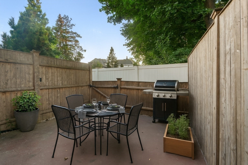 142 Pleasant Street, Unit 2 Winthrop, MA 02152 - Photo 2 of 14 a backyard of a house with table and chairs