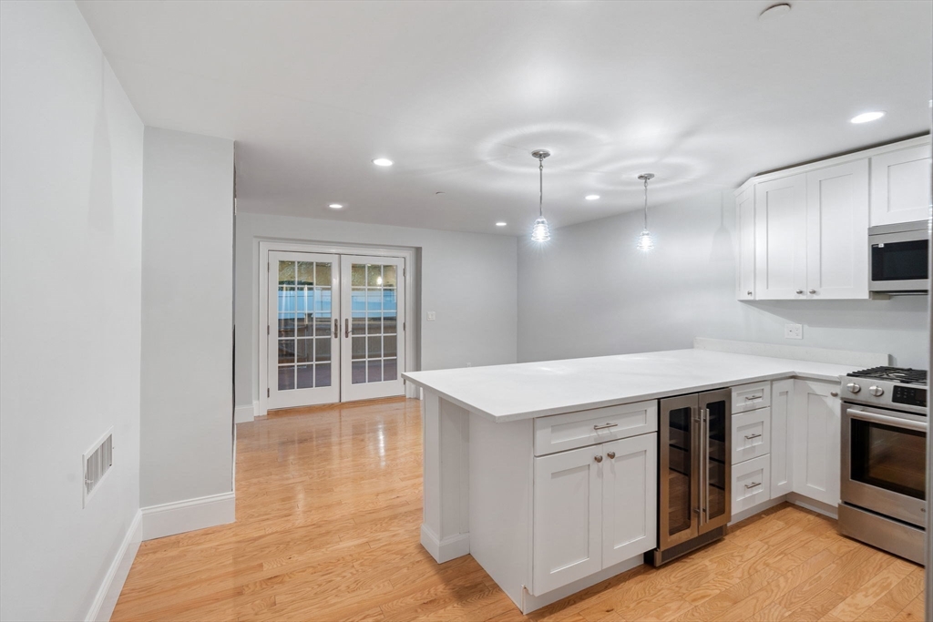 142 Pleasant Street, Unit 2 Winthrop, MA 02152 - Photo 5 of 14 a kitchen with a sink stove and cabinets
