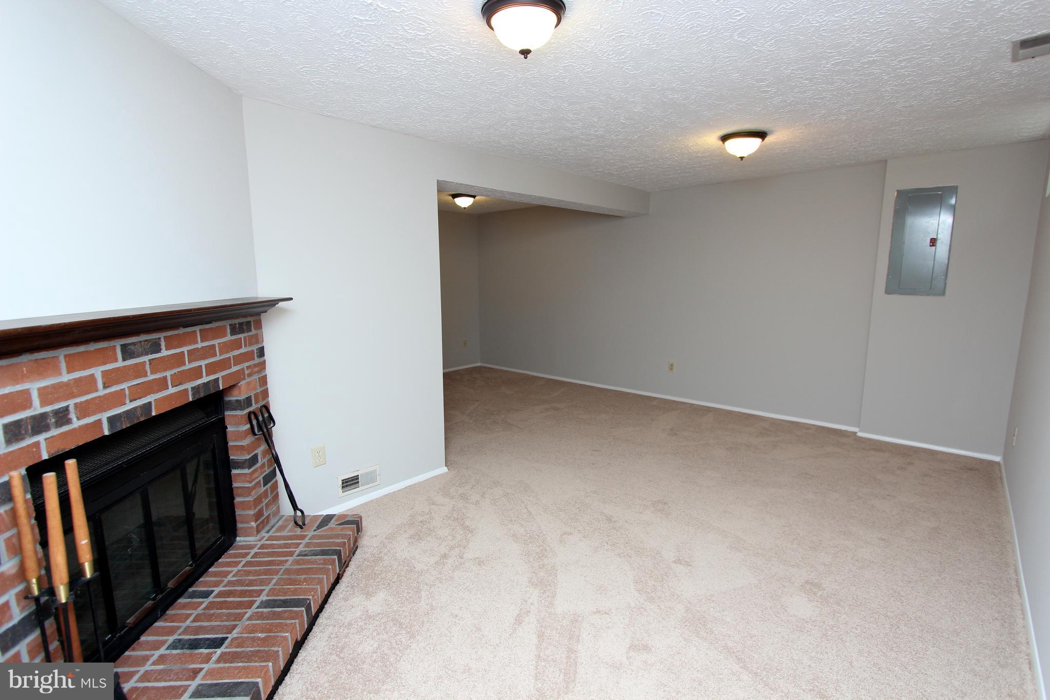 8757 Newington Commons Road Lorton, VA 22079 - Photo 15 of 20 a view of an empty room with wooden floor and a fireplace