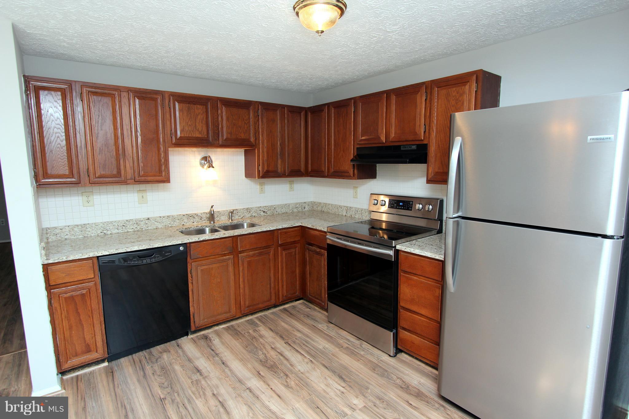 8757 Newington Commons Road Lorton, VA 22079 - Photo 7 of 20 a kitchen with a refrigerator sink and cabinets