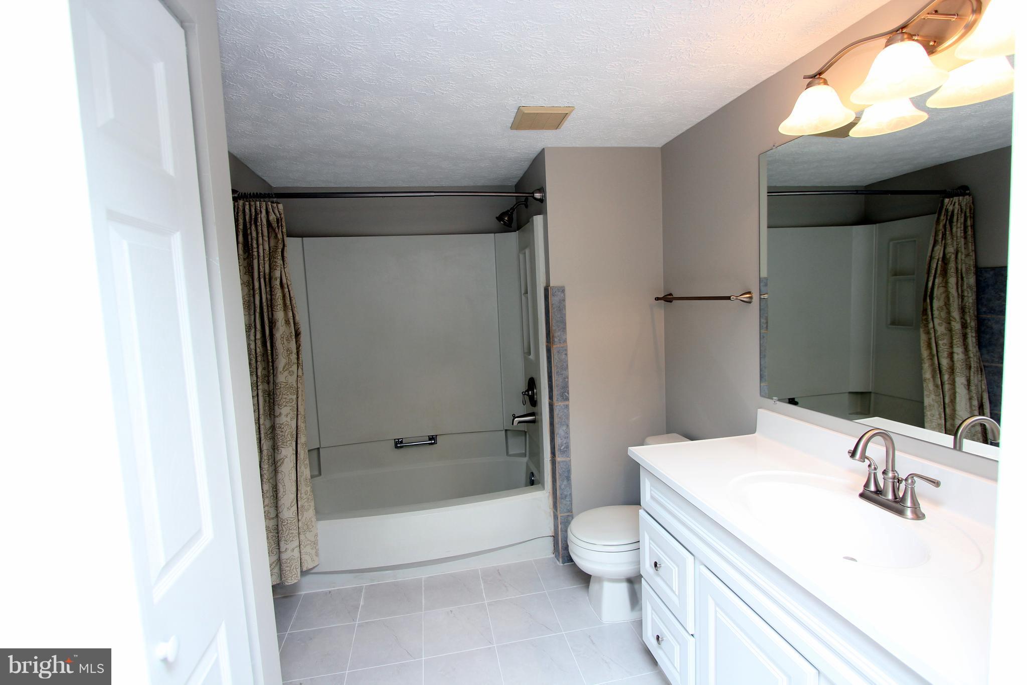 8757 Newington Commons Road Lorton, VA 22079 - Photo 8 of 20 a bathroom with a sink toilet and shower