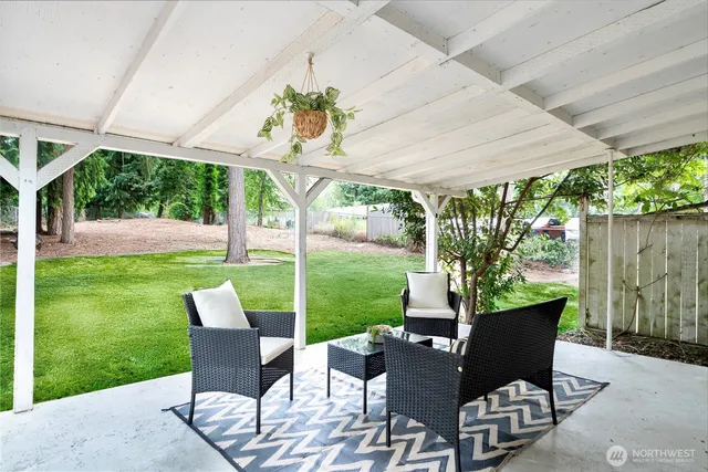 a view of a patio with a table chairs and a yard