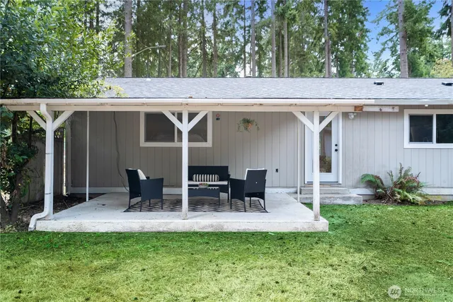 a view of a patio with table and chairs potted plants and large tree