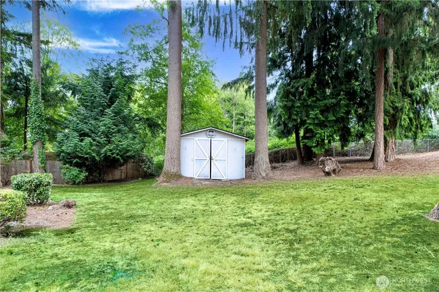 a view of a house with backyard and a tree