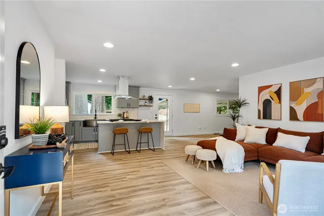 a living room with furniture and view of kitchen