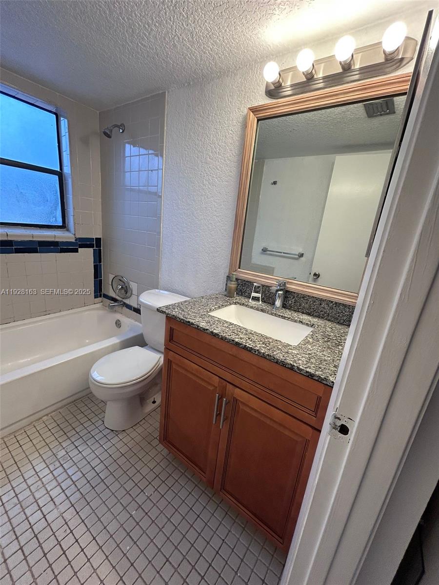 2997 Riverside Drive, Unit 212 Coral Springs, FL 33065 - Photo 11 of 18 a bathroom with a granite countertop sink mirror vanity and toilet