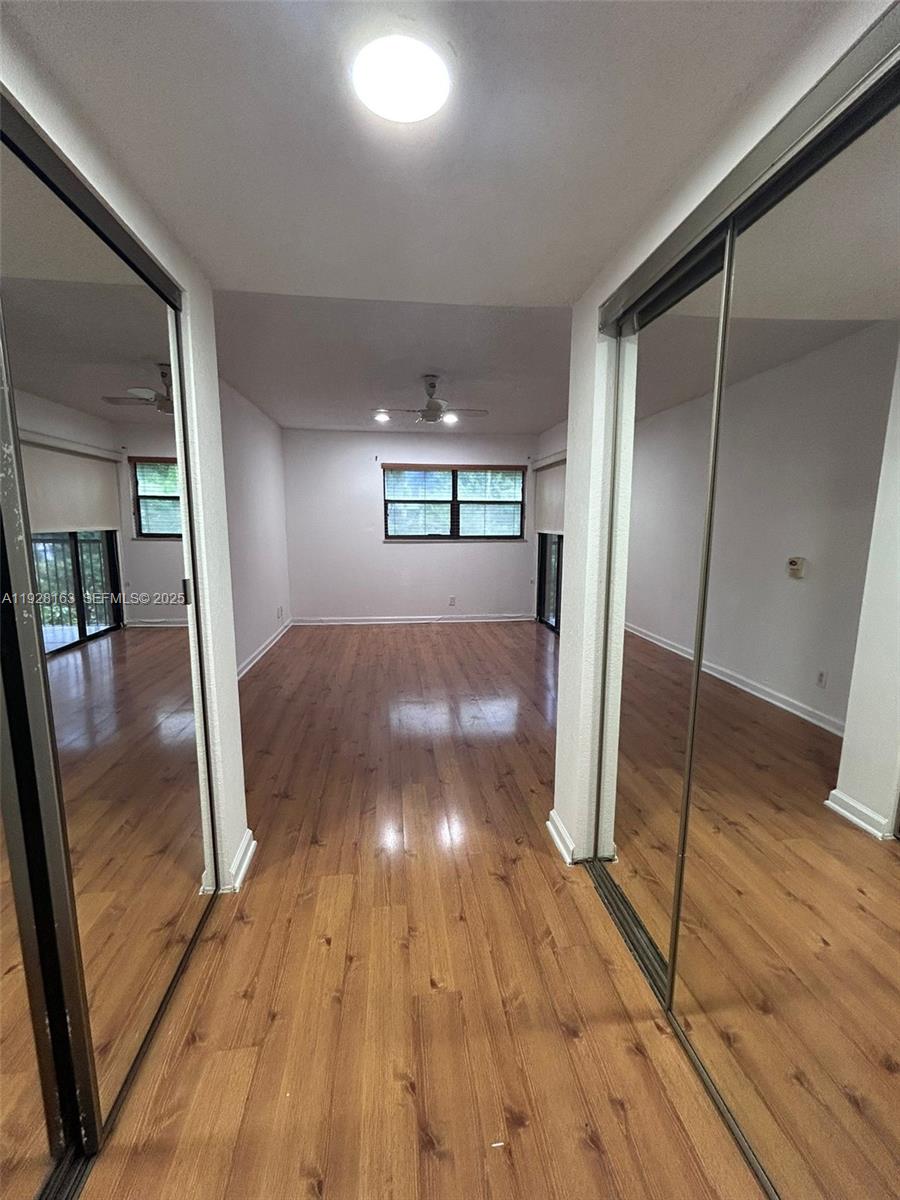 2997 Riverside Drive, Unit 212 Coral Springs, FL 33065 - Photo 17 of 18 a view of a hallway with wooden floor and a living room