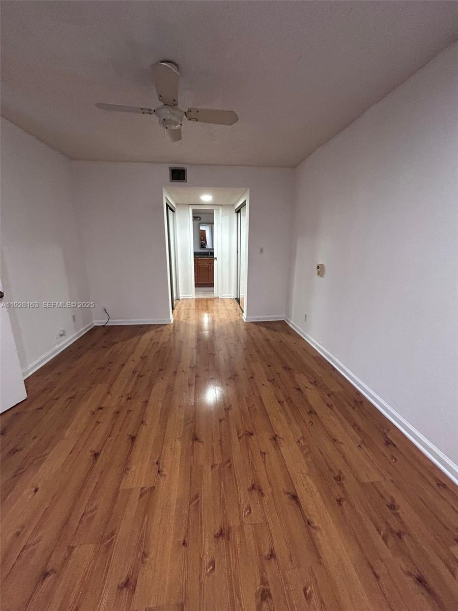 2997 Riverside Drive, Unit 212 Coral Springs, FL 33065 - Photo 18 of 18 a view of empty room with wooden floor and ceiling fan