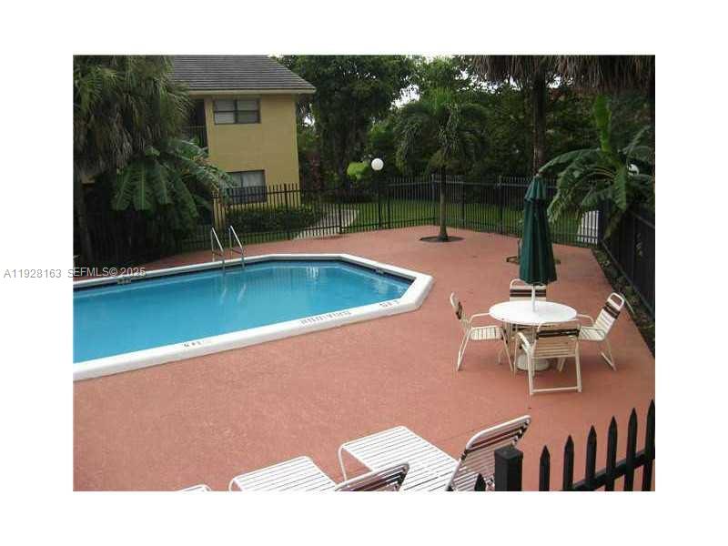 2997 Riverside Drive, Unit 212 Coral Springs, FL 33065 - Photo 4 of 18 a view of a swimming pool with a table and chairs