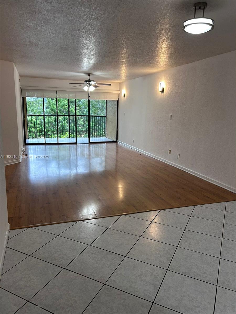 2997 Riverside Drive, Unit 212 Coral Springs, FL 33065 - Photo 6 of 18 an empty room with floor to ceiling windows and fan