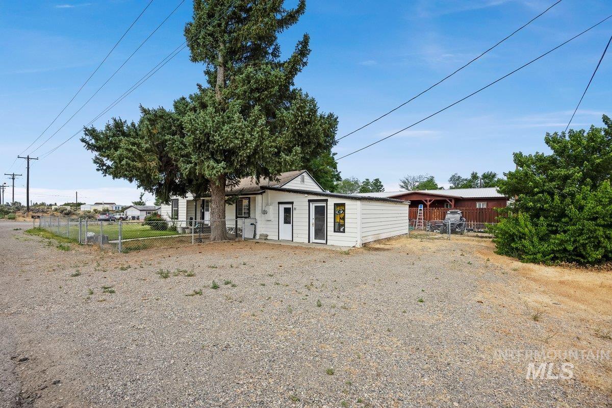 418 South Date Street Shoshone, ID 83352 - Photo 4 of 36 White exterior siding with black trim accents and a large mature tree