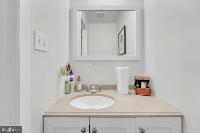 a kitchen with stainless steel appliances granite countertop a refrigerator a sink and white cabinets