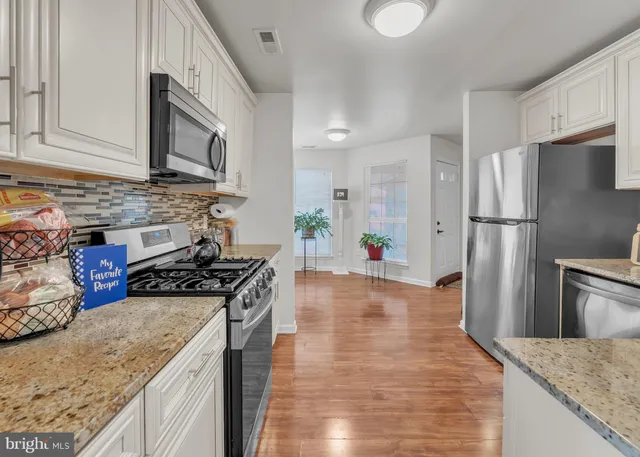 a kitchen with stainless steel appliances a refrigerator and a stove top oven
