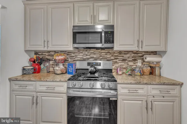 a kitchen with stainless steel appliances granite countertop a stove a microwave and cabinets