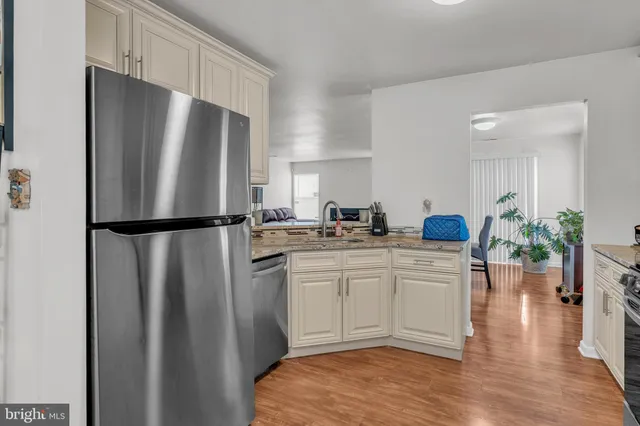 a kitchen with white cabinets sink and a refrigerator