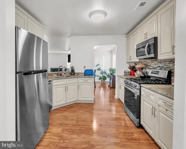 a view of a livingroom with wooden floor and a potted plant