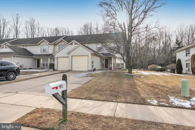 a front view of a house with a yard covered with snow in front of house