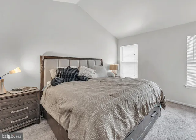 a bedroom with a bed a desk and chair with window
