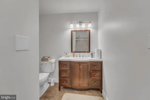 a bathroom with a toilet sink and mirror