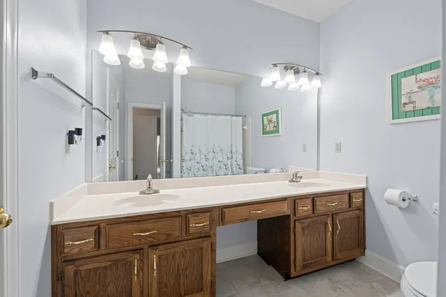 a bathroom with a sink a large mirror and a toilet