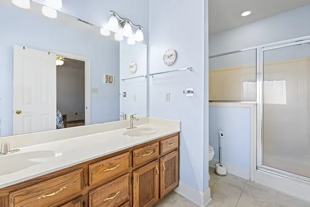 a bathroom with a granite countertop sink mirror and a shower