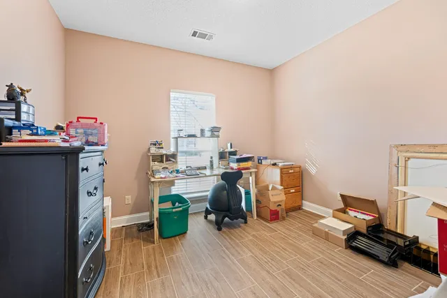 a view of a workspace with furniture and wooden floor