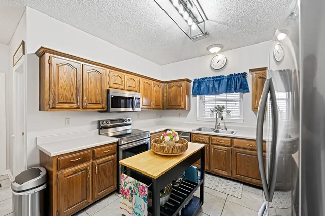 a kitchen with stainless steel appliances a stove refrigerator sink and cabinets