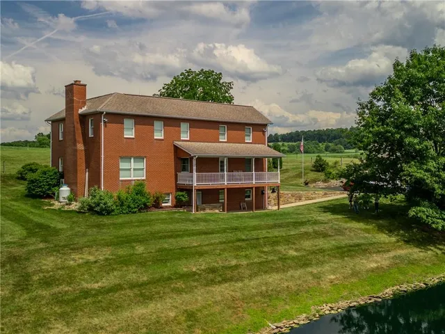 a view of a house with a big yard and large trees
